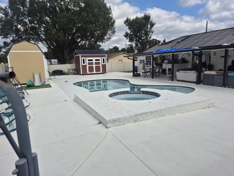 A backyard features a swimming pool, a raised spa, two storage sheds, and a patio — 8016 APACHE LANE, LAKELAND, FL