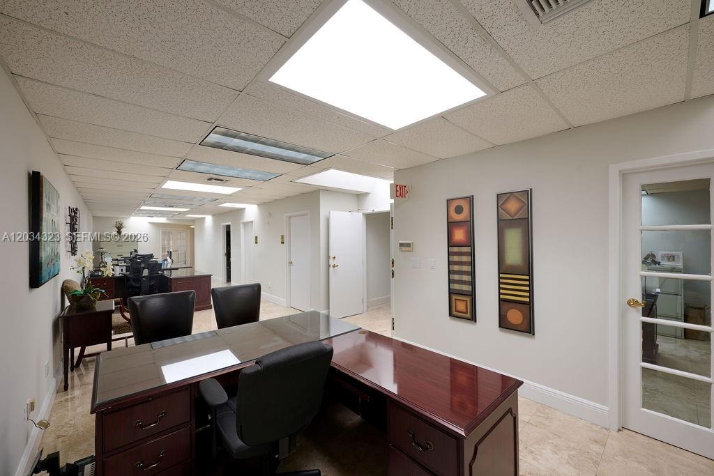 An office space features a dark wood desk, black chairs, and a drop ceiling — 355 Palermo Ave, Coral Gables FL 33134, CORAL GABLES, FL