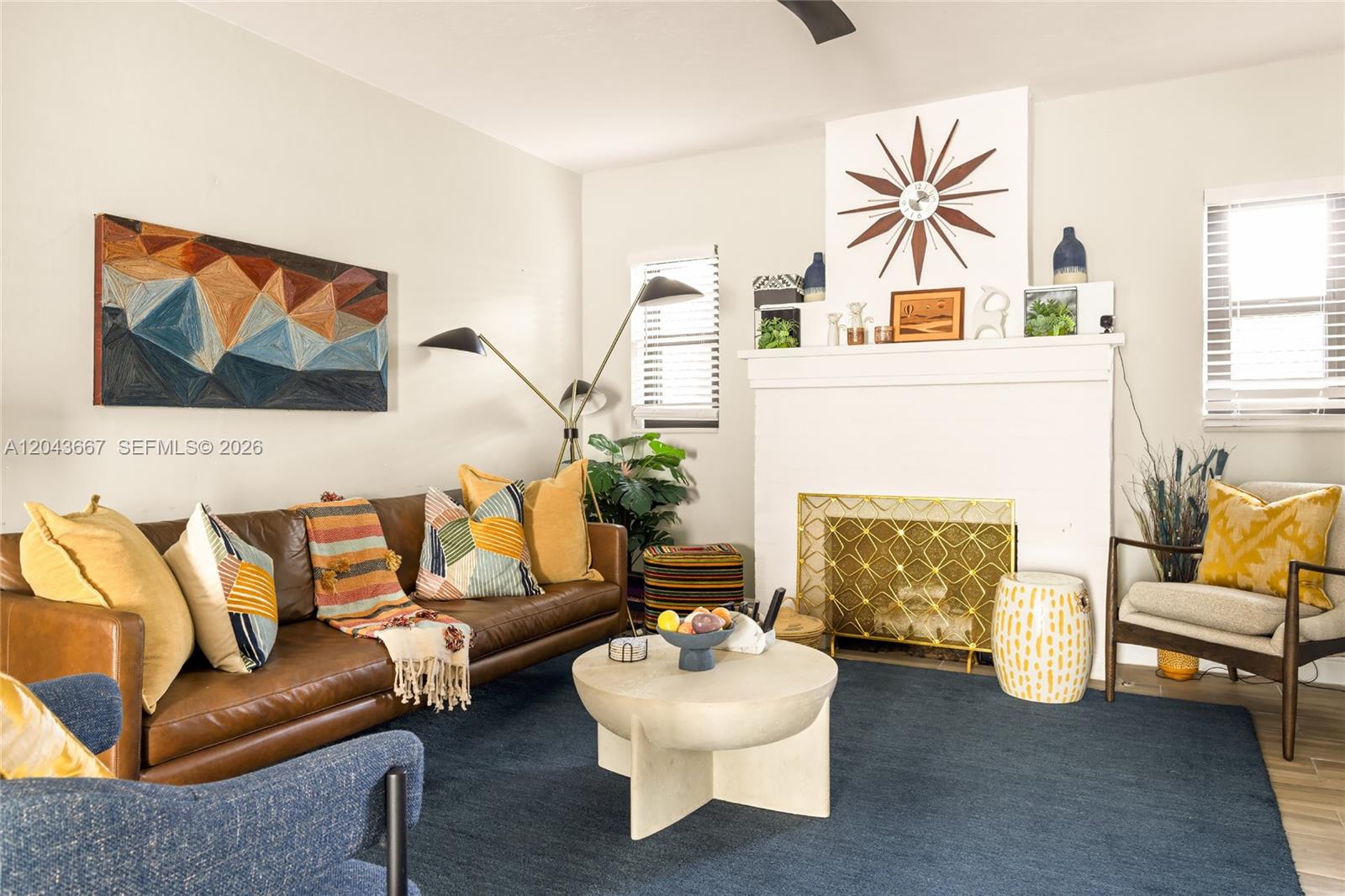 A living room features a brown leather sofa, a fireplace, and a blue area rug — MIAMI, FL