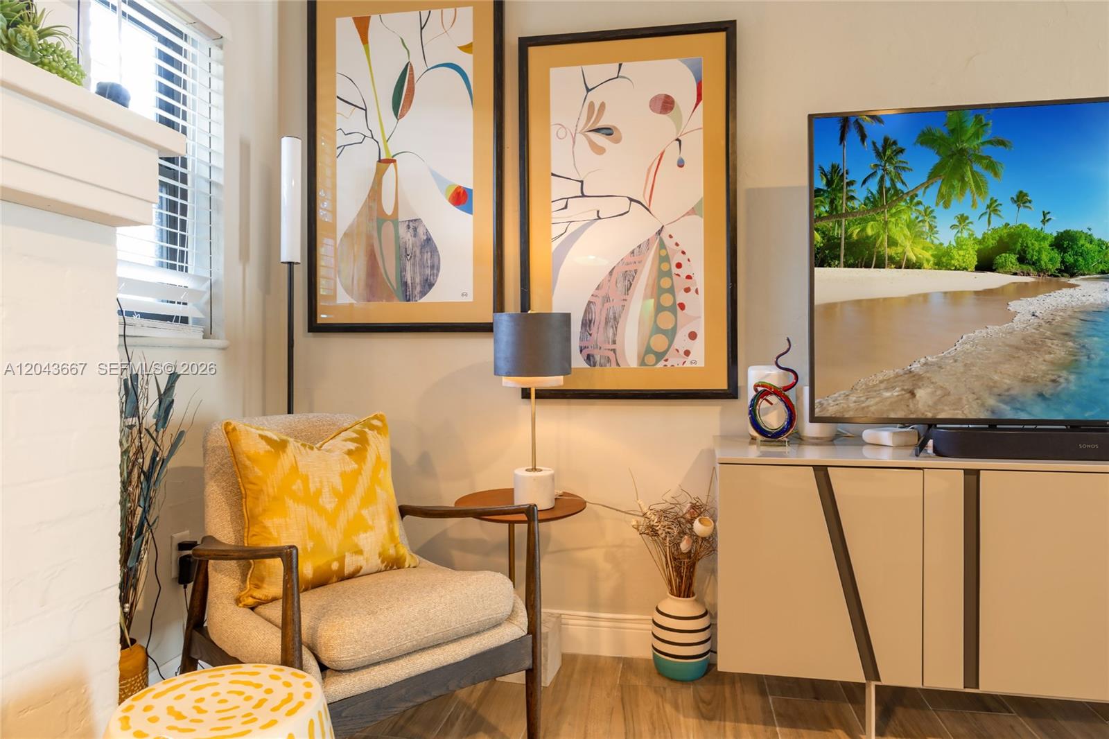 A living room corner features an armchair, a side table with a lamp, and artwork — MIAMI, FL