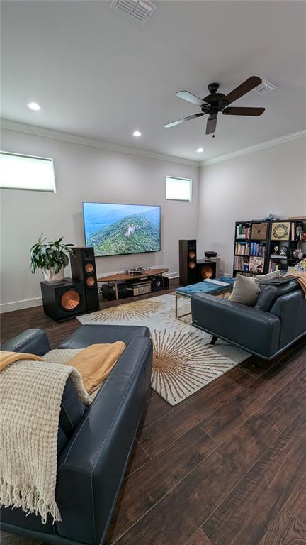 A living room features a wall-mounted television, large speakers, dark leather furniture, and wood flooring — 7476 SW 66TH LANE, GAINESVILLE, FL