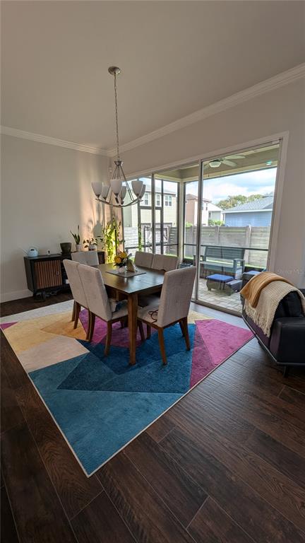 A dining area with a geometric rug, wooden table, and sliding doors to a screened patio — 7476 SW 66TH LANE, GAINESVILLE, FL