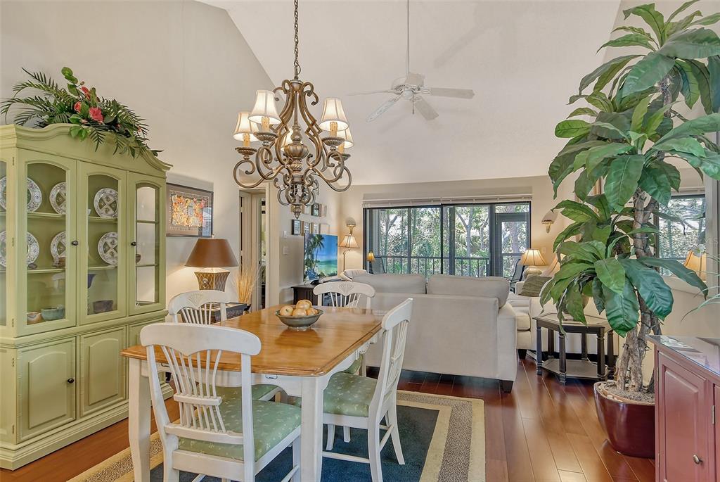 A dining area with a wooden table and hutch opens into a living room — 1720 GLENHOUSE DRIVE UNIT GL430, SARASOTA, FL