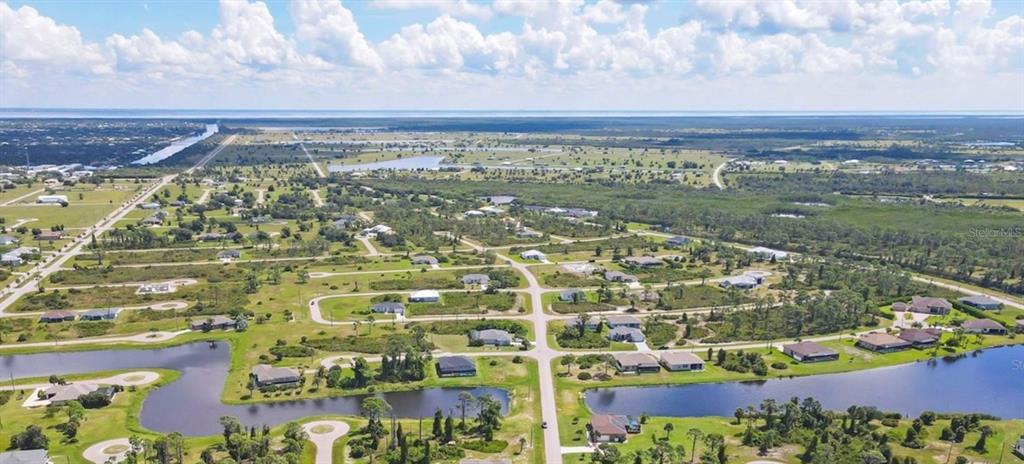 An aerial view shows a residential neighborhood with scattered houses, ponds, and undeveloped land — 14 CATS PAW DRIVE, PLACIDA, FL