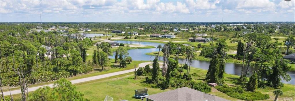 An aerial view shows a house with a backyard, a winding canal, and surrounding vegetation — 14 CATS PAW DRIVE, PLACIDA, FL