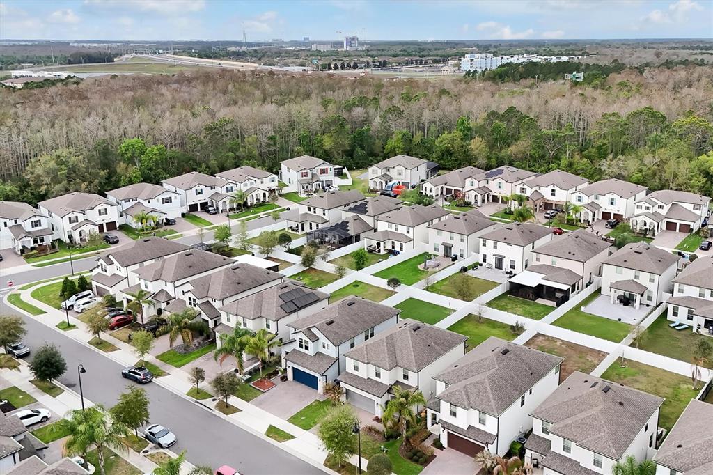 An aerial view shows a suburban neighborhood with multiple two-story houses and paved streets — 9872 AUREA MOSS LANE, ORLANDO, FL