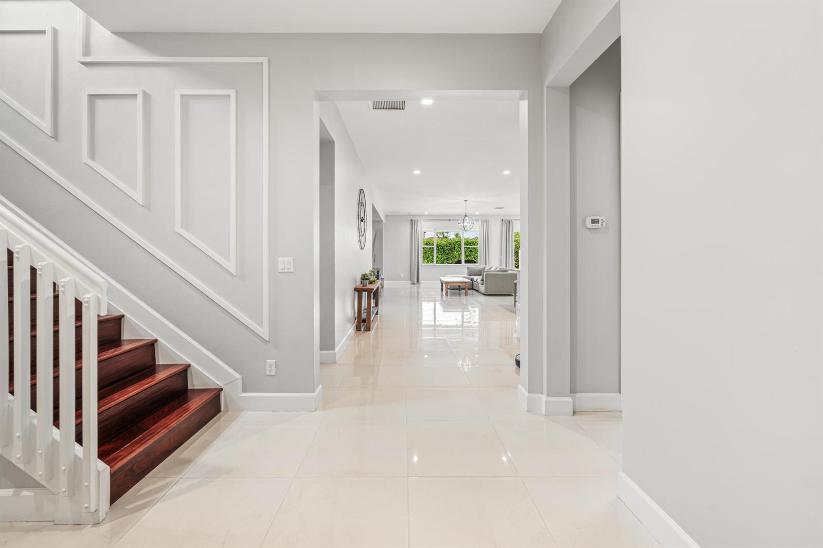 A bright foyer with white tile floors leads to a living area past a staircase — 5095 Beland Drive, Lake Worth FL 33467, LAKE WORTH, FL
