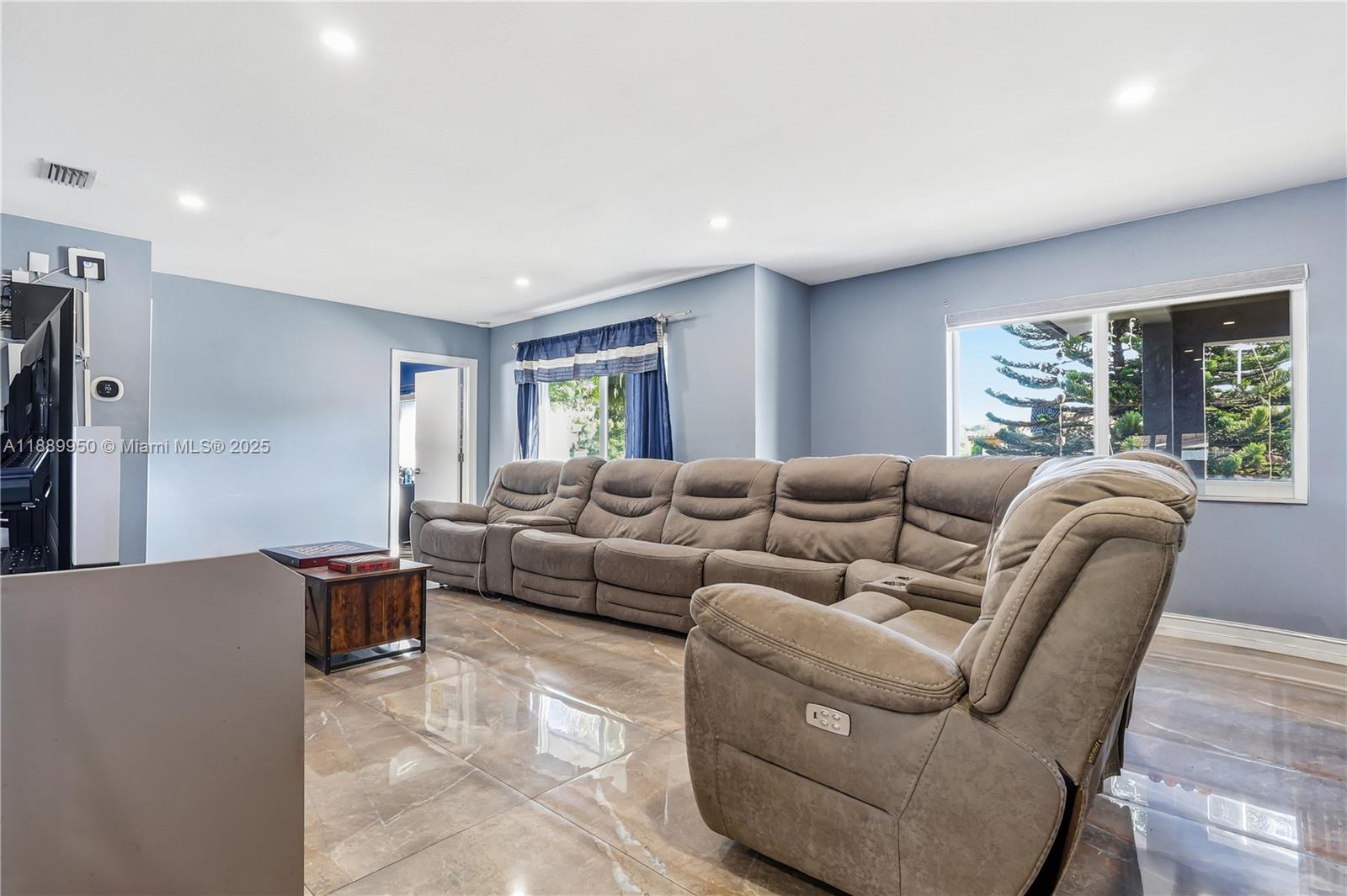 A living room features a large sectional sofa, tile flooring, and light blue walls — 9795 NW 27th Ter, Doral FL 33172, DORAL, FL