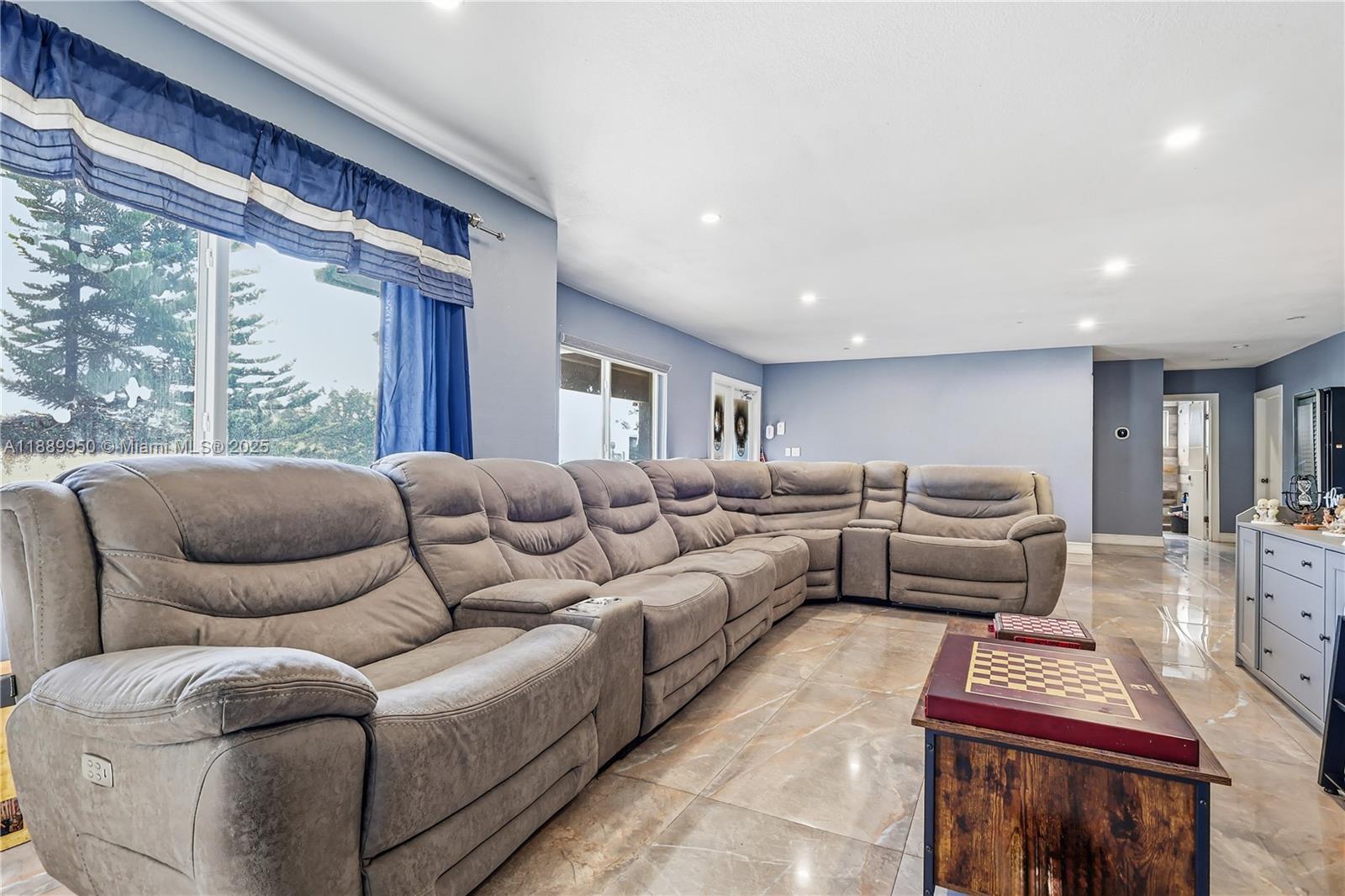 A living room features a large gray sectional sofa, tiled floors, and blue curtains — 9795 NW 27th Ter, Doral FL 33172, DORAL, FL