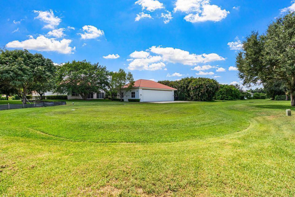 A detached garage sits on a large, grassy lawn under a bright blue sky — 15465 Take Off Place, Wellington FL 33414, WELLINGTON, FL