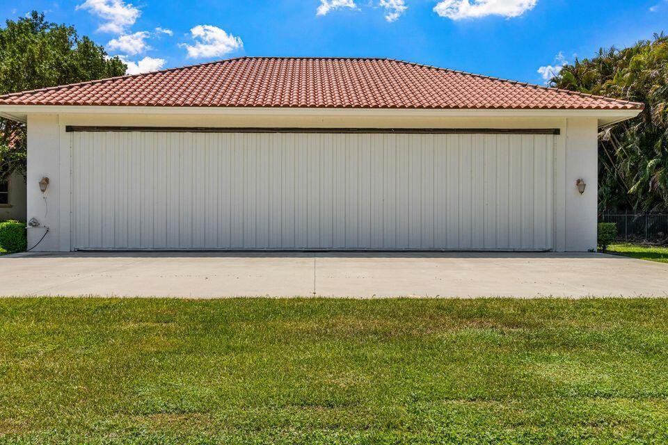 A detached garage with a wide white door and a red tile roof — 15465 Take Off Place, Wellington FL 33414, WELLINGTON, FL