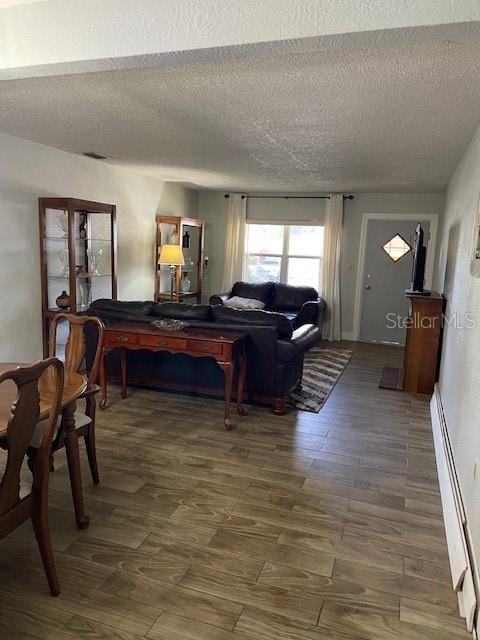 A living room features wood-look tile flooring, a dark leather sofa, and a wooden console table — 6800 ANOKA DRIVE, ORLANDO, FL