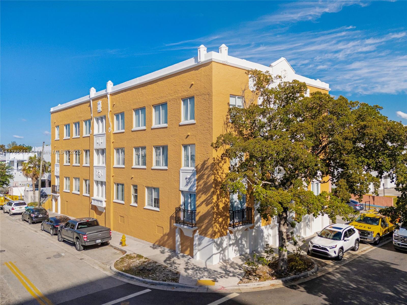 A three-story yellow apartment building with white trim stands on a street corner — 440 SW 5th Ave, Miami FL 33130, MIAMI, FL