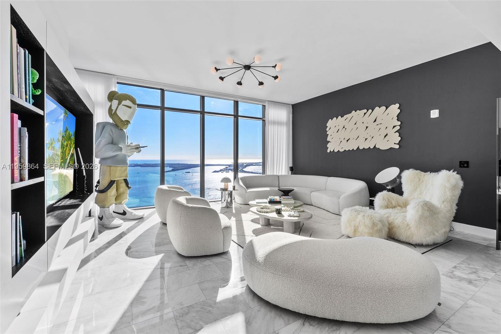 A modern living room features a large sculpture, white curved furniture, and floor-to-ceiling ocean views — 1451 Brickell Ave # 4401, Miami FL 33131, MIAMI, FL