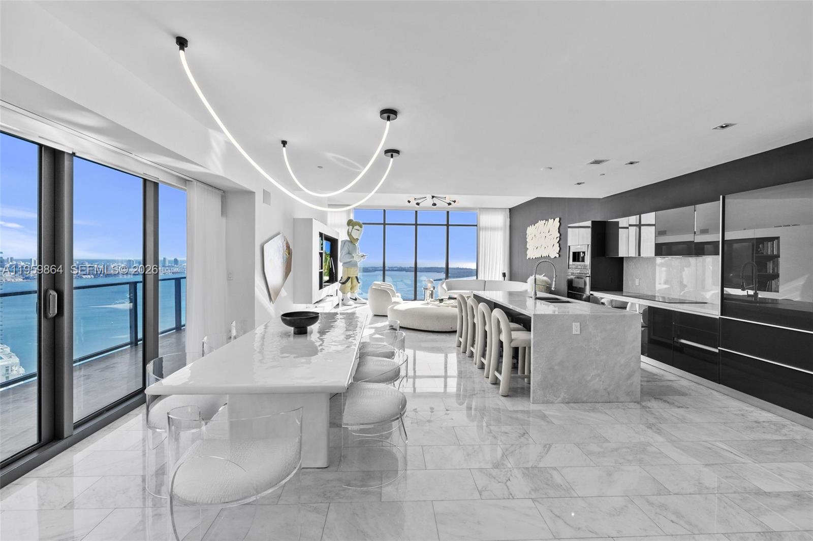 A modern open-concept kitchen and dining area features marble flooring, a large island, and ocean views — 1451 Brickell Ave # 4401, Miami FL 33131, MIAMI, FL