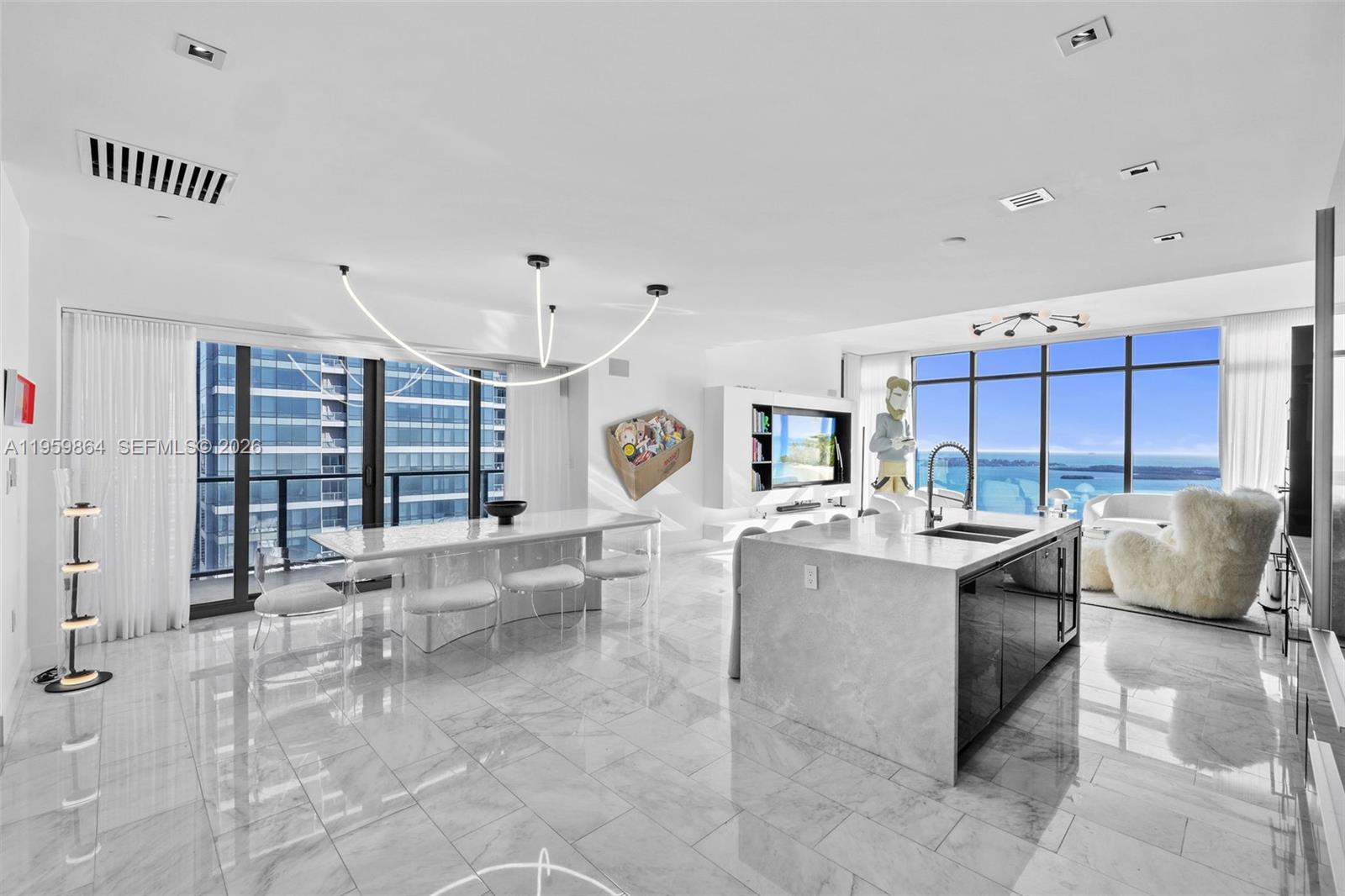 A modern, open-concept living and dining area features marble floors, floor-to-ceiling windows, and ocean views — 1451 Brickell Ave # 4401, Miami FL 33131, MIAMI, FL