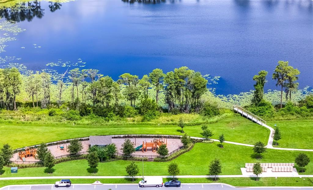 An aerial view shows a playground and a walking path next to a large lake — 13617 SALAMANDER STREET, WINTER GARDEN, FL