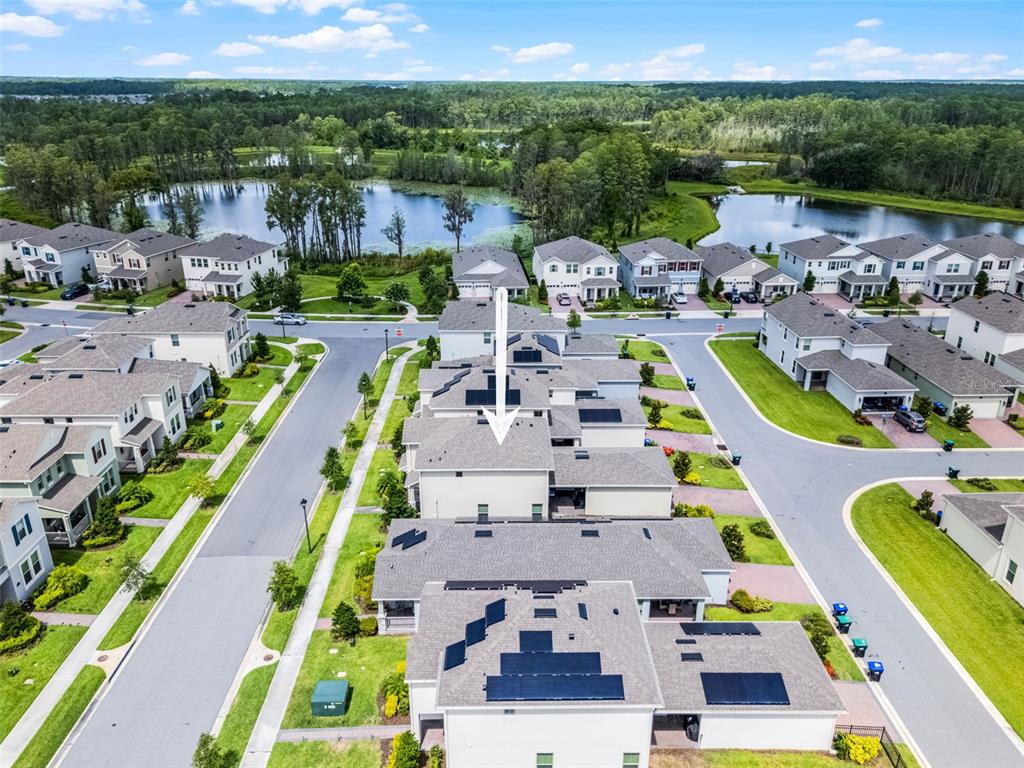 An aerial view shows a row of suburban townhomes with solar panels on the roofs — 13617 SALAMANDER STREET, WINTER GARDEN, FL