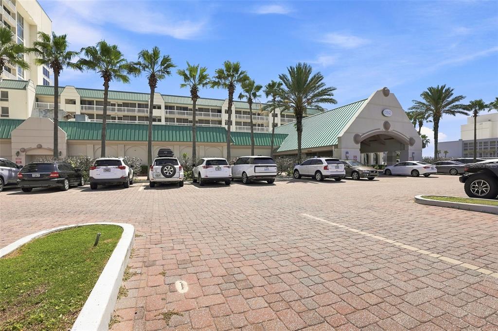 A paved parking lot sits in front of a multi-story building with palm trees — 2700 N ATLANTIC AVENUE UNIT 407, DAYTONA BEACH, FL