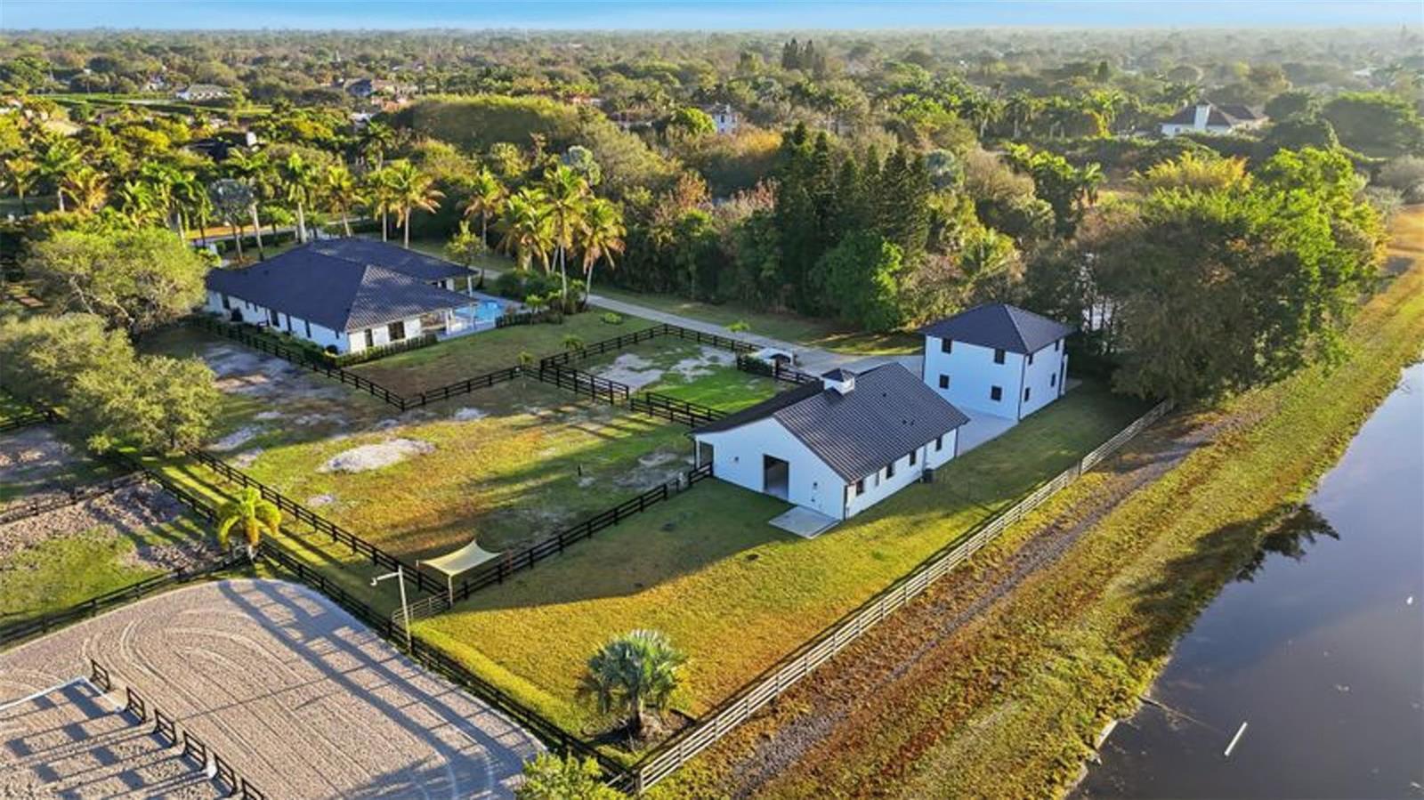 An aerial view shows a house, a barn, and a riding arena on a property — 14473 Draft Horse Lane, Wellington FL 33414, WELLINGTON, FL
