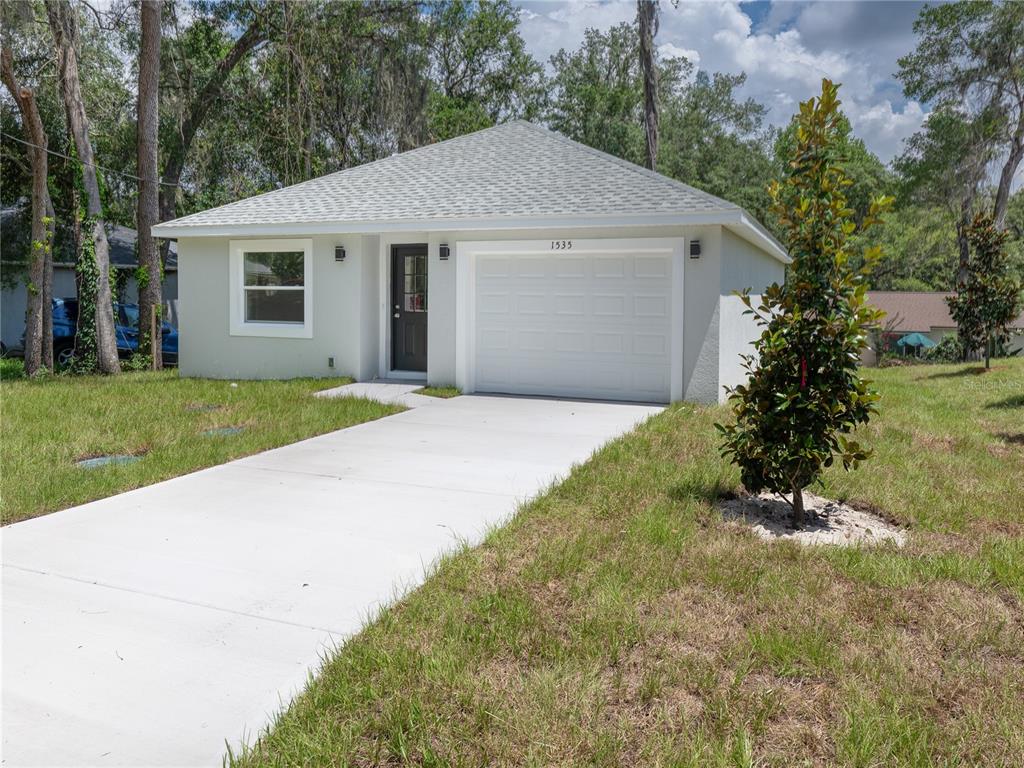 A single-story house with a white garage door, a front door, and a concrete driveway — 1535 18TH STREET, ORANGE CITY, FL