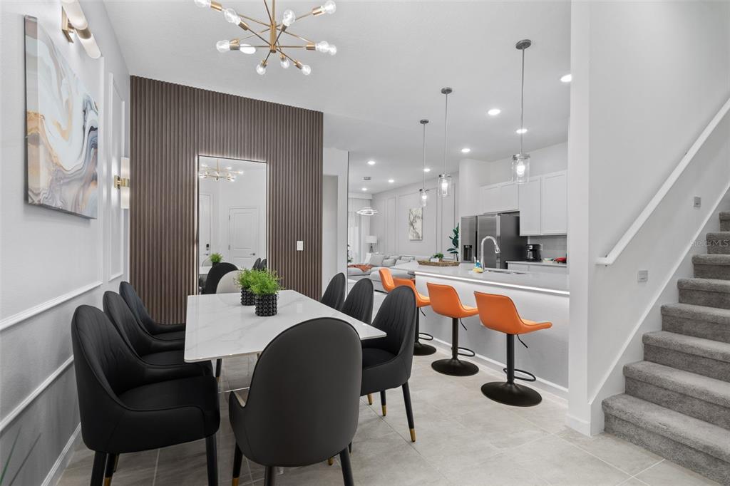 A dining area with a marble table and black chairs sits beside an open kitchen — 10467 EBB TIDE LANE, ORLANDO, FL