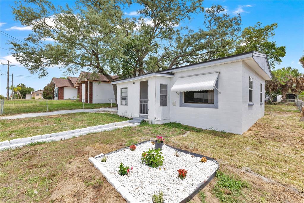 A small, white, single-story house with a white rock garden in the front yard — 423 N 5TH STREET, HAINES CITY, FL