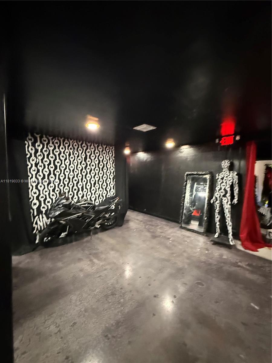 A dark room features a motorcycle, a chain-patterned wall, a mirror, and a mannequin — 777 NE 79th St, Miami FL 33138, MIAMI, FL