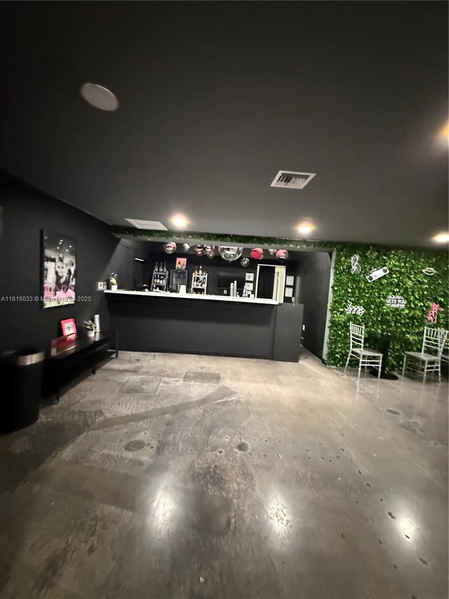 A room with a black bar, concrete floors, and a green wall feature — 777 NE 79th St, Miami FL 33138, MIAMI, FL