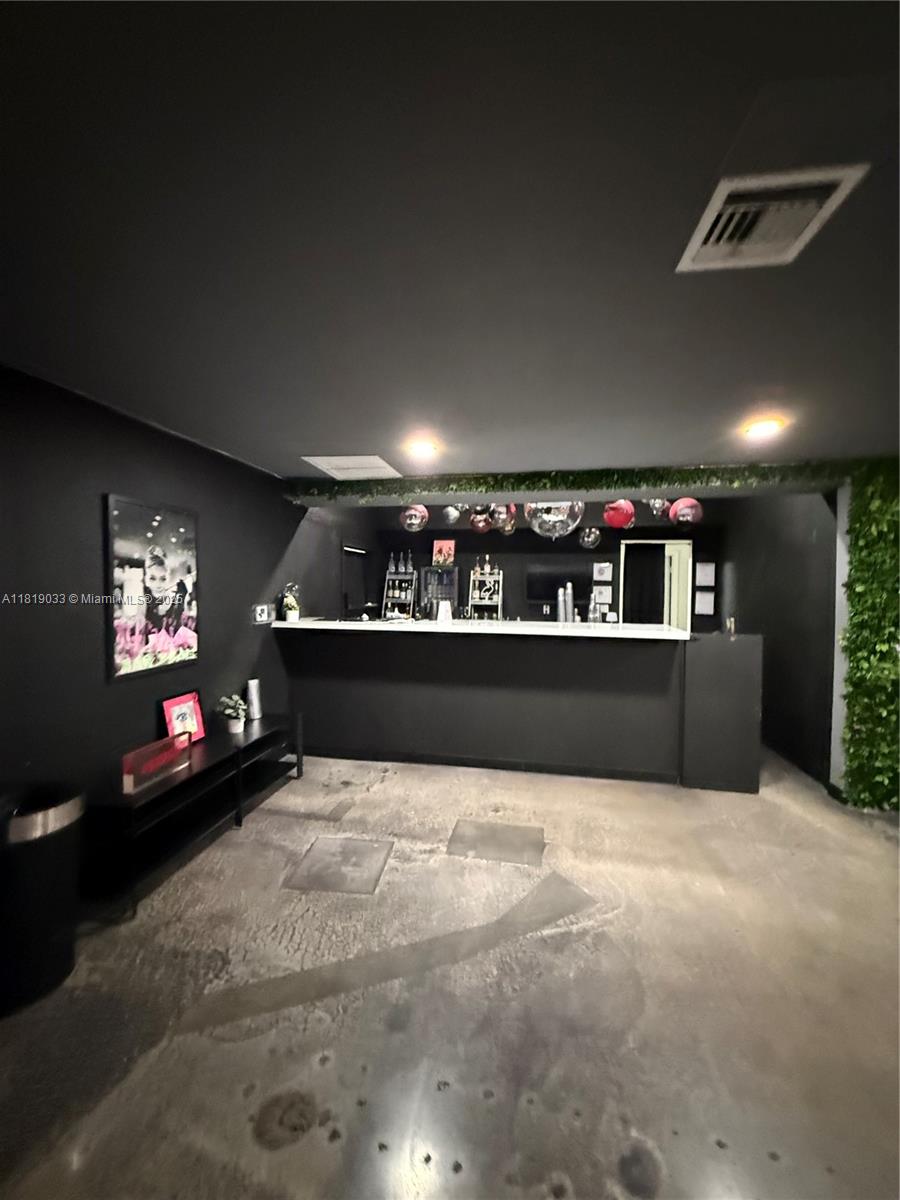 A room with a black bar, concrete floors, and a green wall accent — 777 NE 79th St, Miami FL 33138, MIAMI, FL