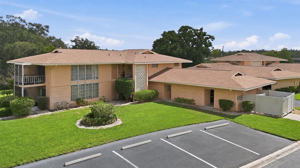 An exterior view of a two-story peach-colored apartment building with a parking lot — 2223 BENEVA TERRACE UNIT 2222, SARASOTA, FL