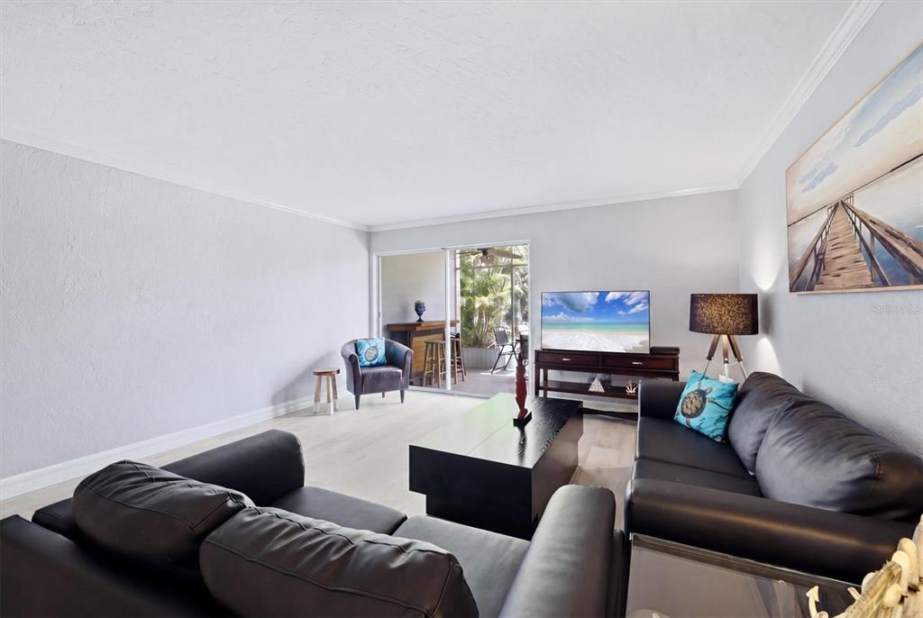 A living room features dark leather sofas, a coffee table, and a sliding glass door — 2223 BENEVA TERRACE UNIT 2222, SARASOTA, FL
