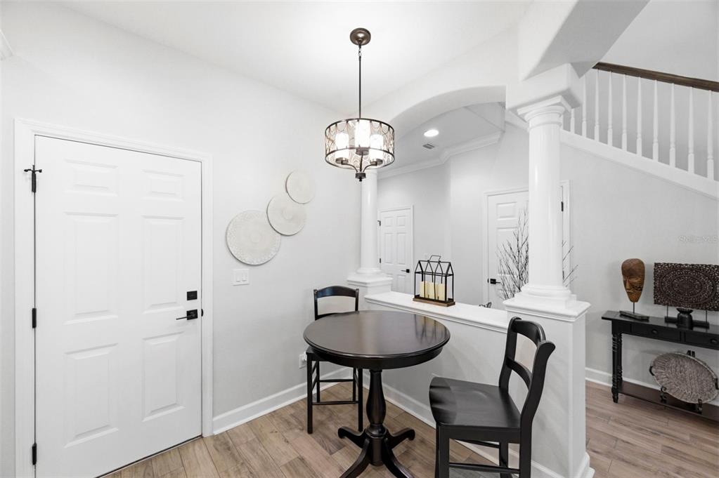 A small dining area features a round table, two chairs, and a hanging light fixture — 2670 TANGLEWOOD TRAIL, PALM HARBOR, FL