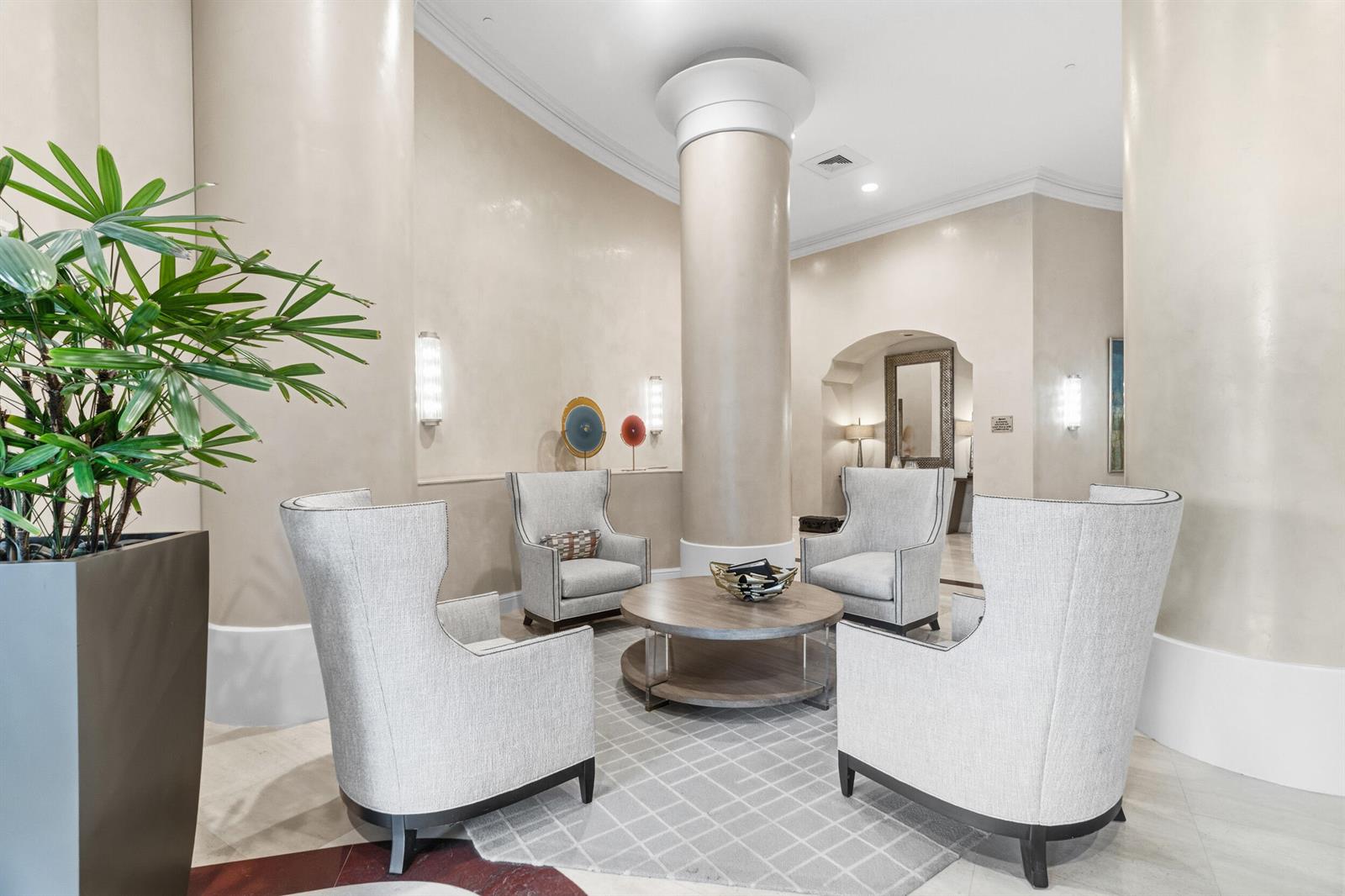 A seating area with four armchairs around a round wooden table in a lobby — 3740 S Ocean Boulevard Apt 709, Highland Beach FL 33487, HIGHLAND BEACH, FL