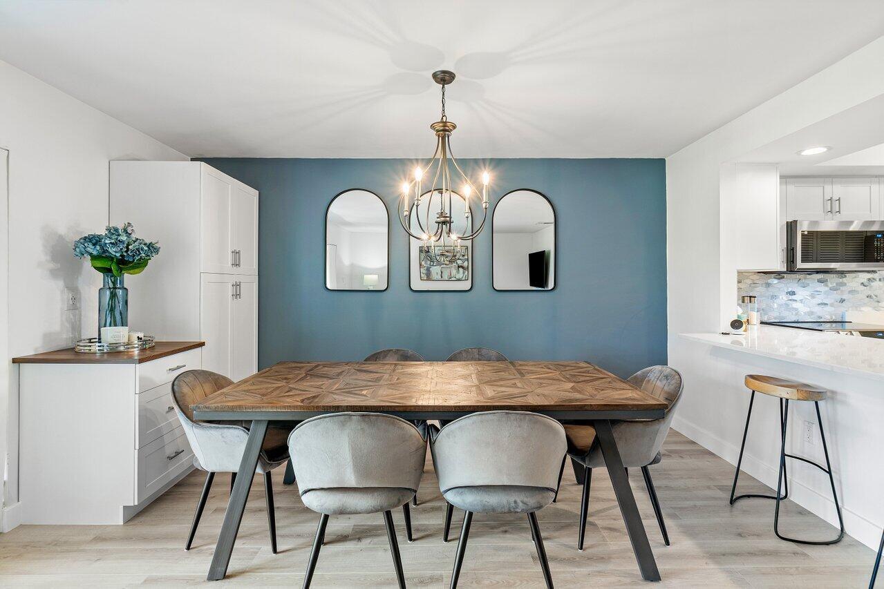 A dining room features a wooden table, grey chairs, and a blue accent wall — 4143 Kittiwake Court, Boynton Beach FL 33436, BOYNTON BEACH, FL