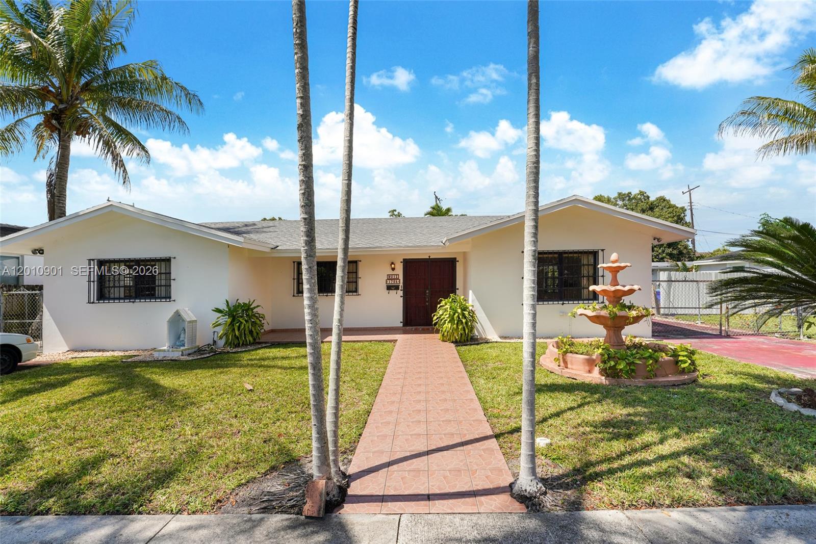 A single-story house with a tiled walkway, a fountain, and palm trees in the front yard — 1735 SW 15th St, Miami FL 33145, MIAMI, FL
