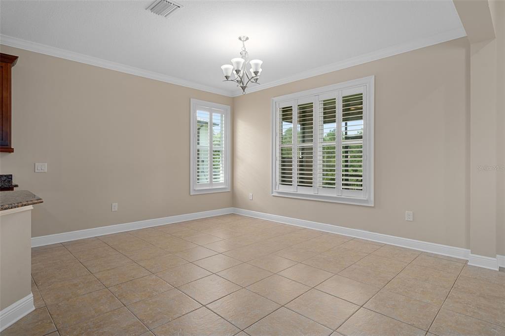 A bathroom features a central glass-enclosed shower flanked by two wooden vanities with granite countertops — 4551 SOUTHERN VALLEY LOOP, BROOKSVILLE, FL