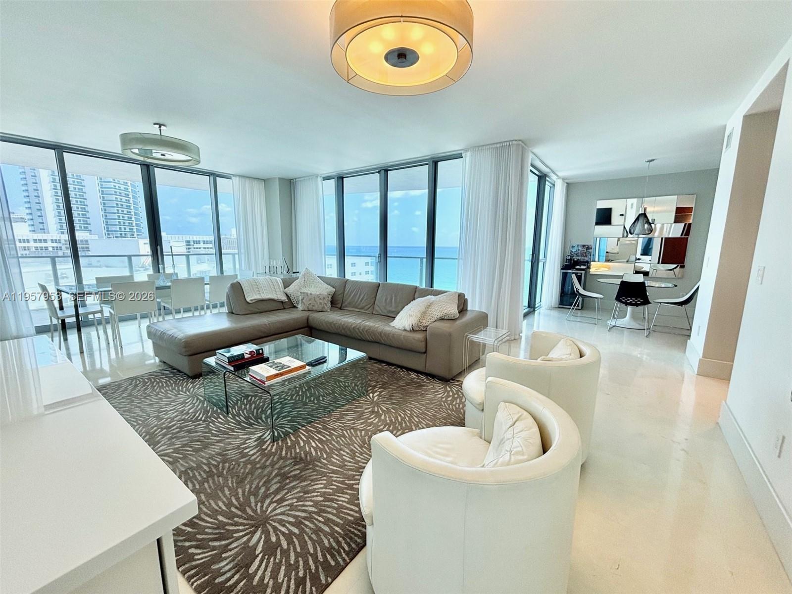 A modern living room features a large sectional sofa, glass coffee table, and ocean views — 3101 S Ocean Dr # 1701, Hollywood FL 33019, HOLLYWOOD, FL