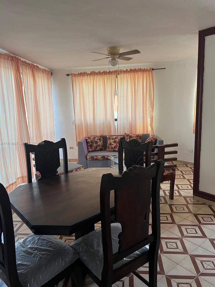 A dining area with a wooden table and chairs sits before a living room space — No.10 Calle Bohechio, DR foreign, DR