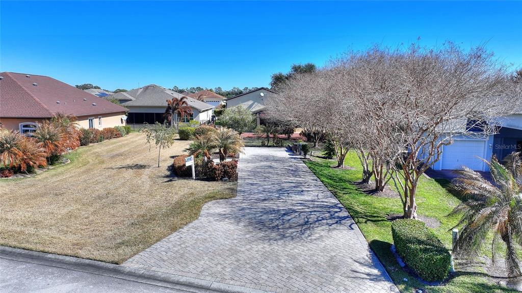 A paved driveway leads to a house with a garage and a large front lawn — 427 TRAVELERS DRIVE, POLK CITY, FL