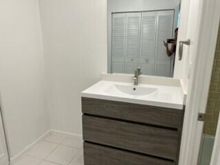 A bedroom features a bed with a green runner, a window, and a wooden nightstand — 3540 S Ocean Boulevard # 208, South Palm Beach FL 33480, SOUTH PALM BEACH, FL