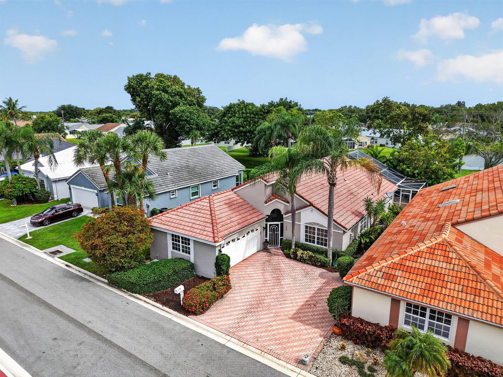 An aerial view shows a single-story house with a red tile roof and paved driveway — 7558 Ironbridge Circle, Delray Beach FL 33446, DELRAY BEACH, FL