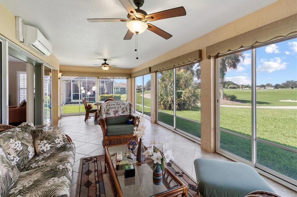 A sunroom with tile floors, ceiling fans, and large windows overlooking a golf course — 2314 CALLAWAY DRIVE, THE VILLAGES, FL