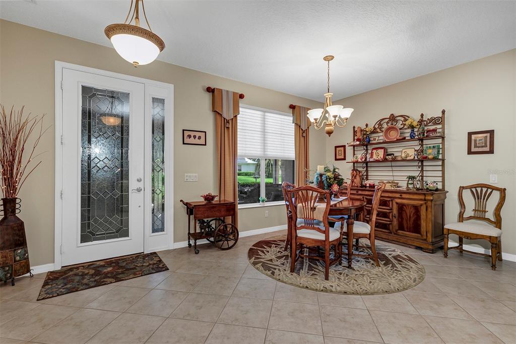 A dining area features tile flooring, a wooden table with chairs, and a hutch — 4348 ANTIETAM CREEK TRAIL, LEESBURG, FL