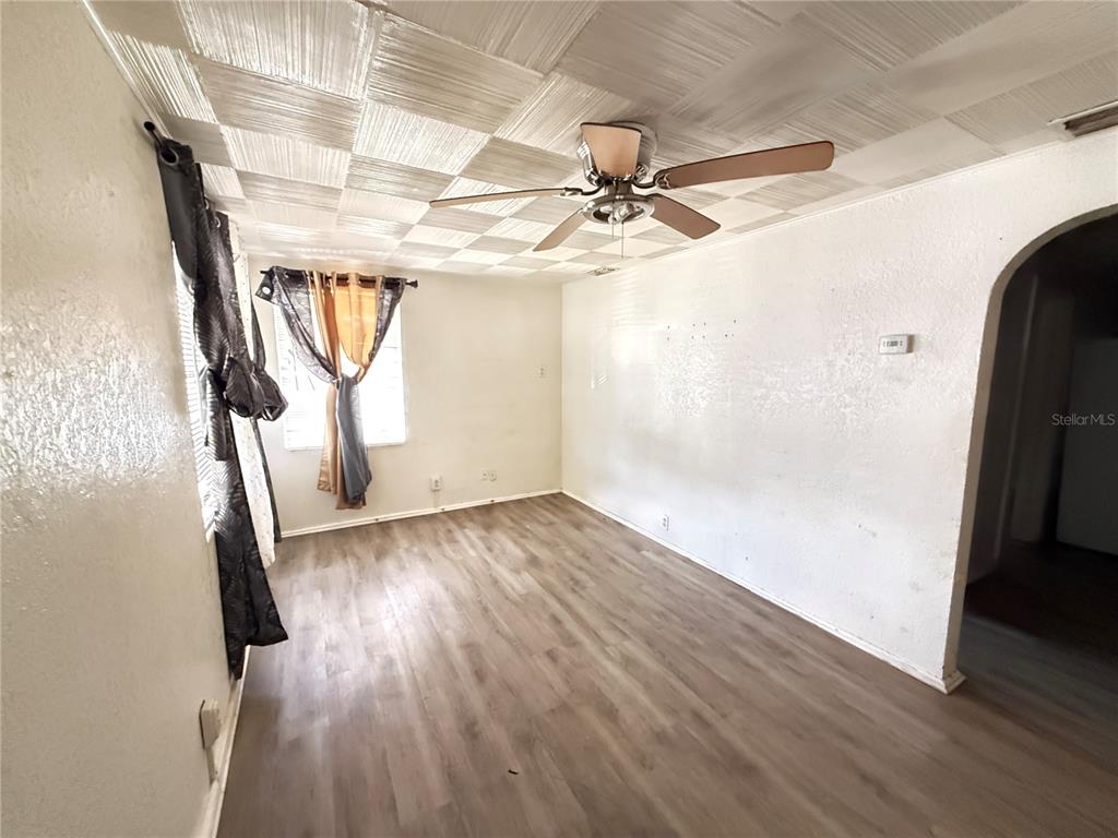 A living room features wood-look flooring, white walls, and a textured square-patterned ceiling — 1117 BRACK STREET, KISSIMMEE, FL