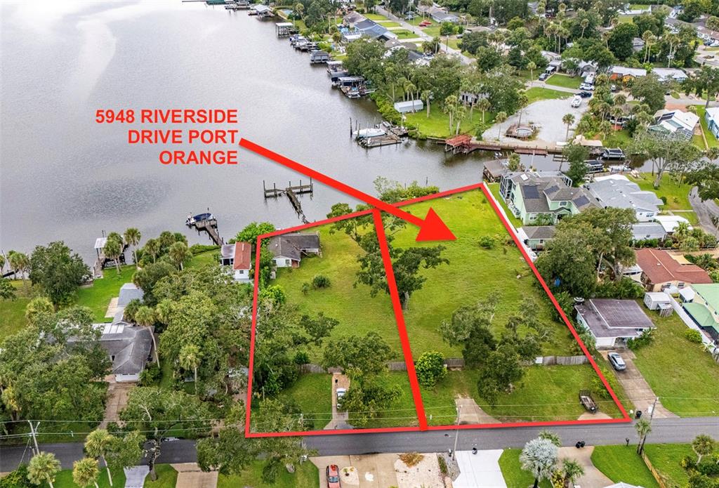 This aerial view shows a vacant waterfront lot outlined in red along a residential street — 5948 RIVERSIDE DRIVE, PORT ORANGE, FL