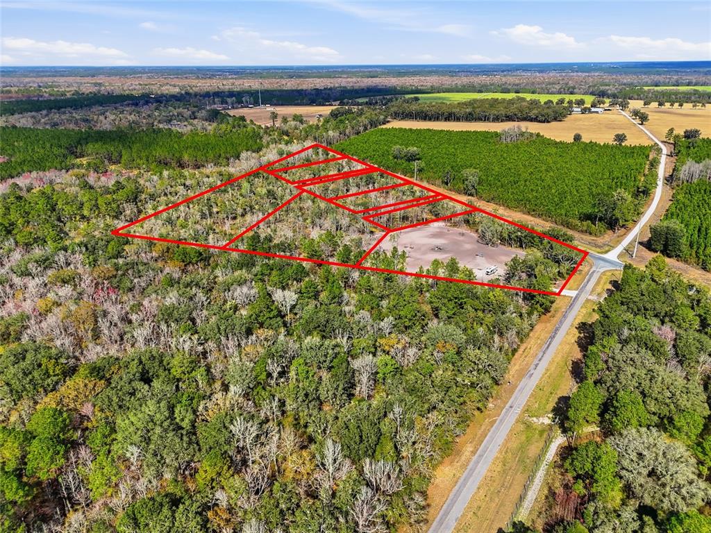An aerial view shows a wooded plot of land outlined in red near a road — 20994 SW COUNTY ROAD 18 Lot 6, BROOKER, FL