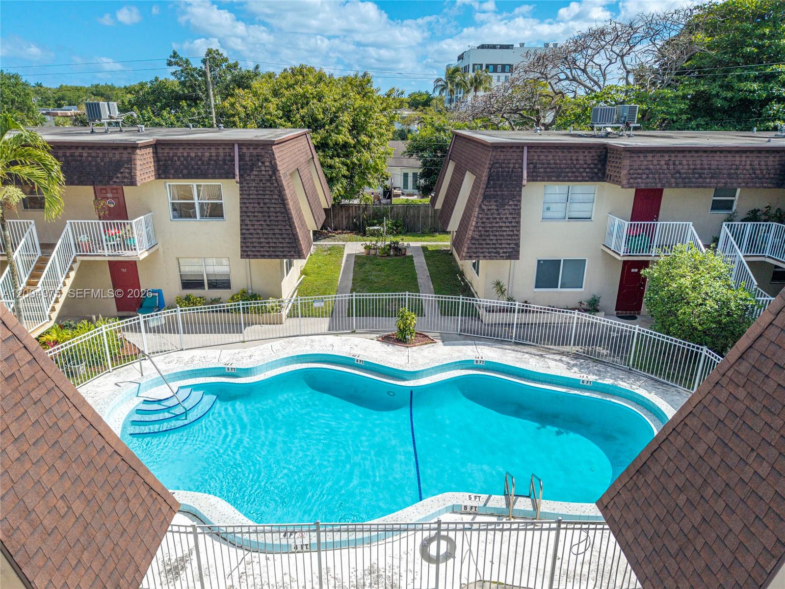 An elevated view shows a swimming pool situated between two multi-story apartment buildings — 4524 SW 54th St, Dania Beach FL 33314, DANIA BEACH, FL