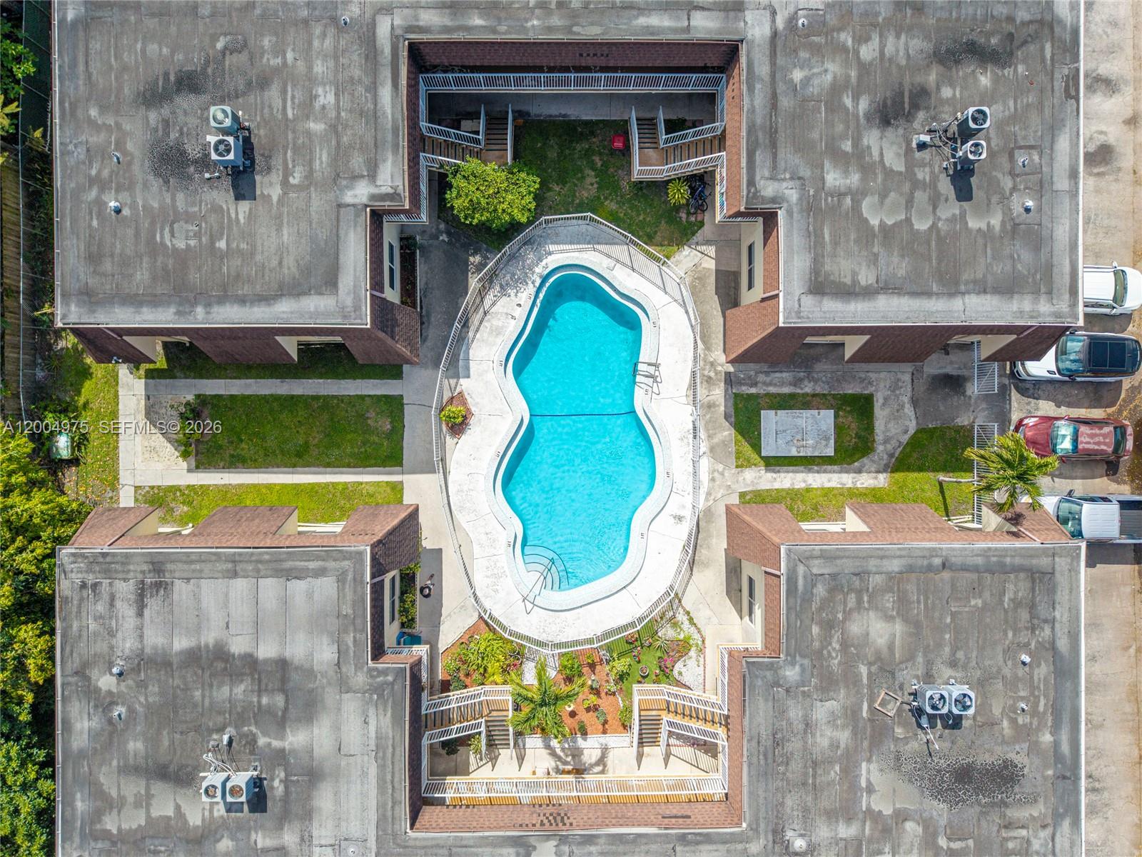 An aerial view shows a swimming pool centered within a U-shaped apartment complex — 4524 SW 54th St, Dania Beach FL 33314, DANIA BEACH, FL