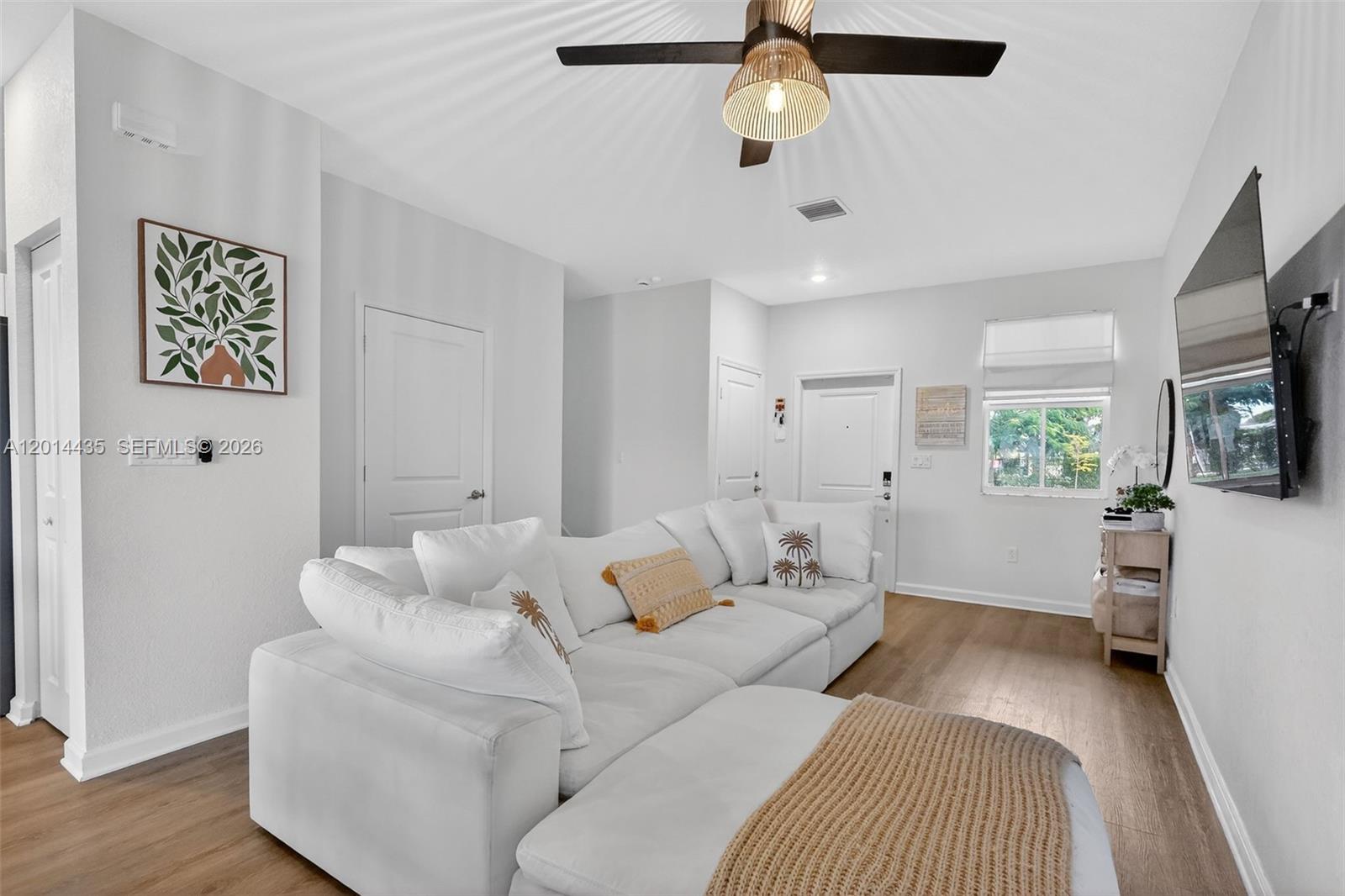 A living room features a white sectional sofa, wood-look flooring, and a ceiling fan — 12808 NW 22nd Pl, Miami FL 33167, MIAMI, FL